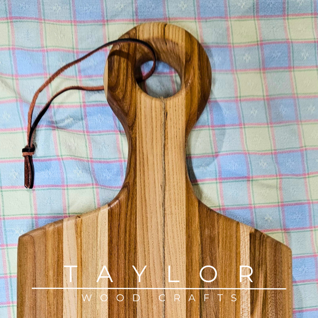 Handcrafted paddle board made from elm wood, featuring a leather string for hanging, offering durability and rustic charm.