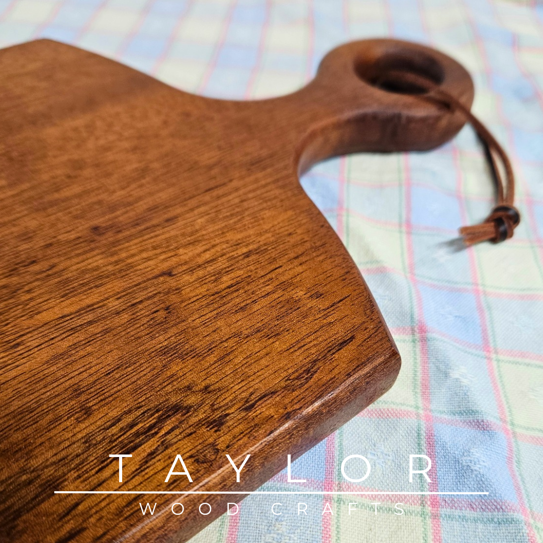 Handcrafted cherry wood paddle board with a smooth, polished surface, highlighting natural grain, perfect as a functional or decorative piece.