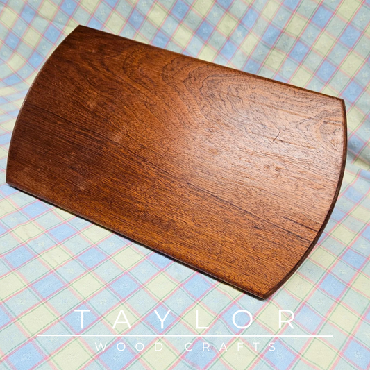 Handcrafted oval cherry wood charcuterie board, showcasing natural grain, perfect for serving appetizers or as a decorative piece.