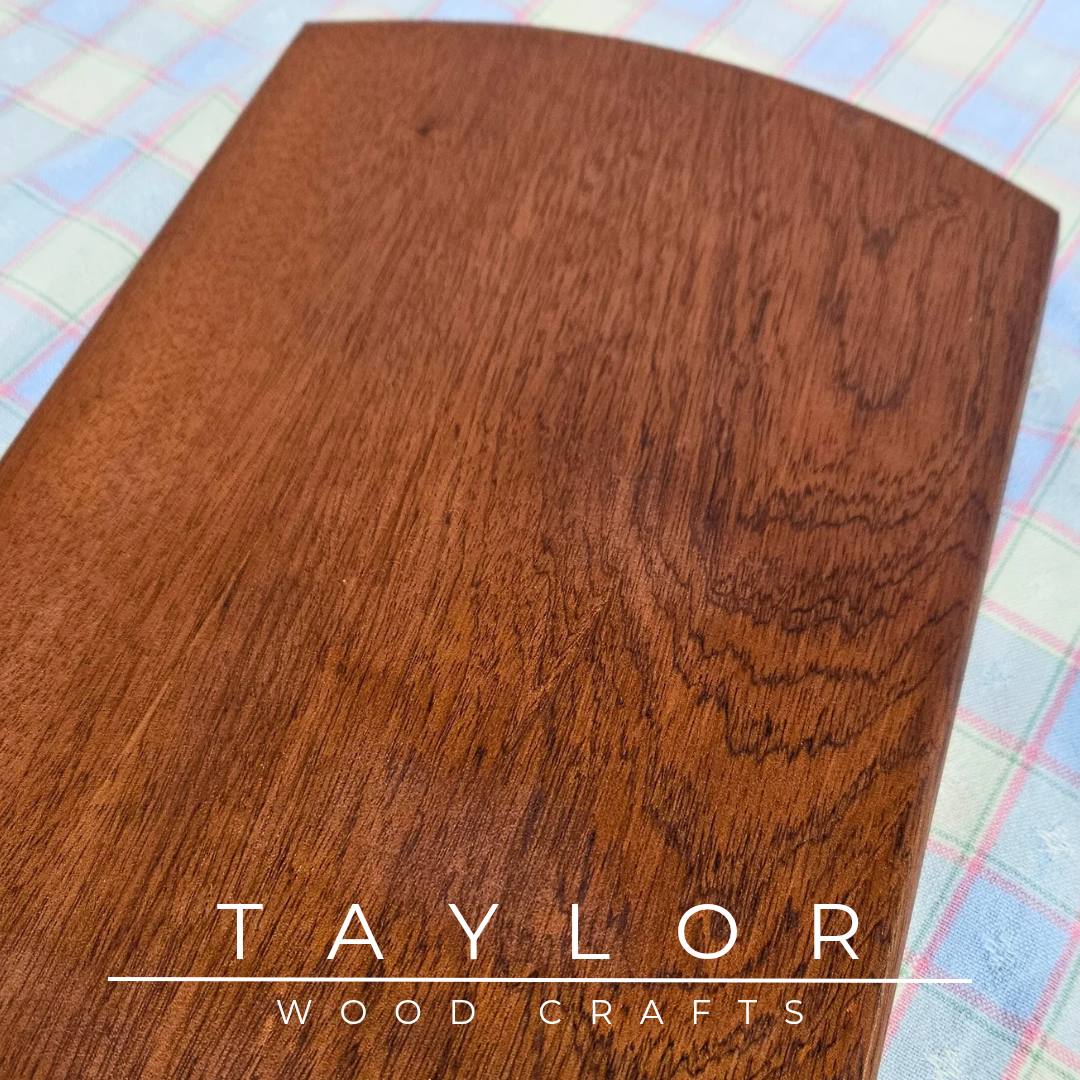 Handcrafted oval cherry wood charcuterie board, showcasing natural grain, perfect for serving appetizers or as a decorative piece.