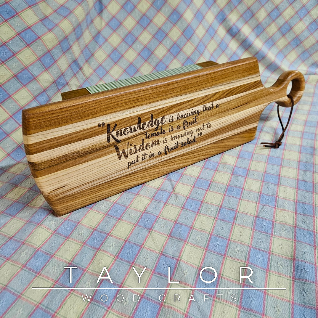 Handcrafted elm wood charcuterie board shaped like a paddle, showcasing rich wood grain for a rustic and elegant touch.