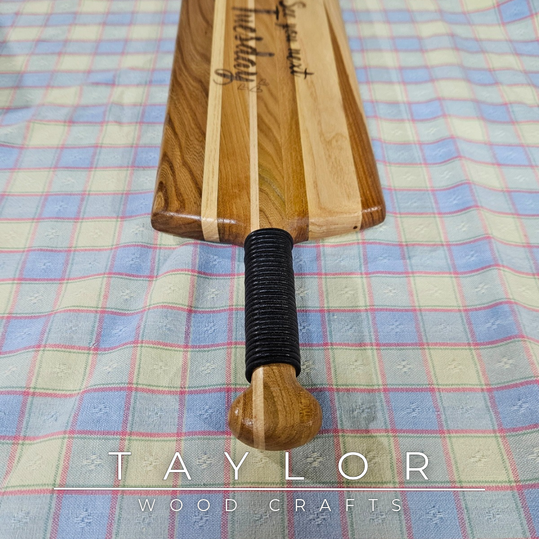 Handcrafted elm wood charcuterie board shaped like a paddle, showcasing rich wood grain for a rustic and elegant touch.