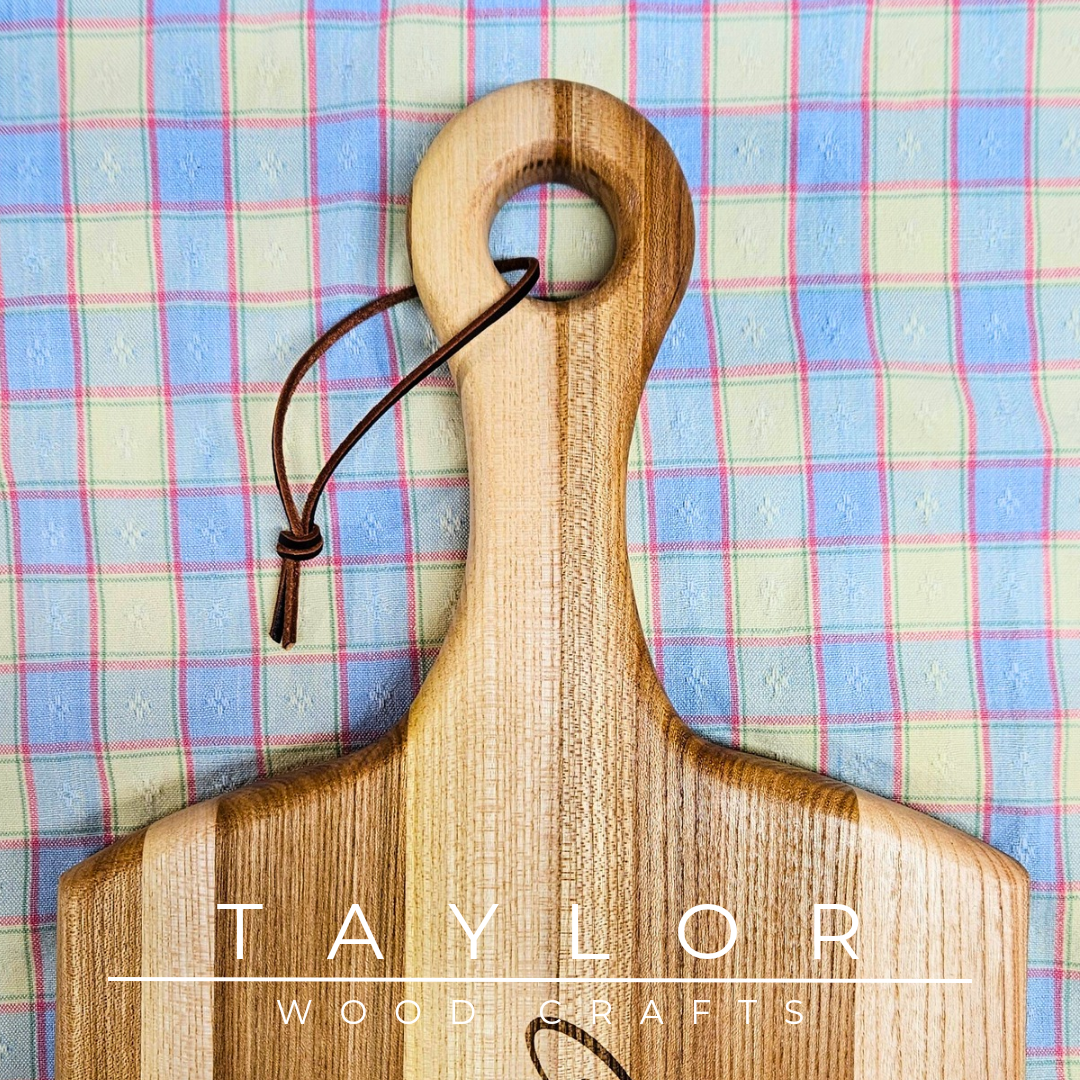 Handcrafted paddle board with a leather string for hanging, combining rustic charm and functionality for serving or display.