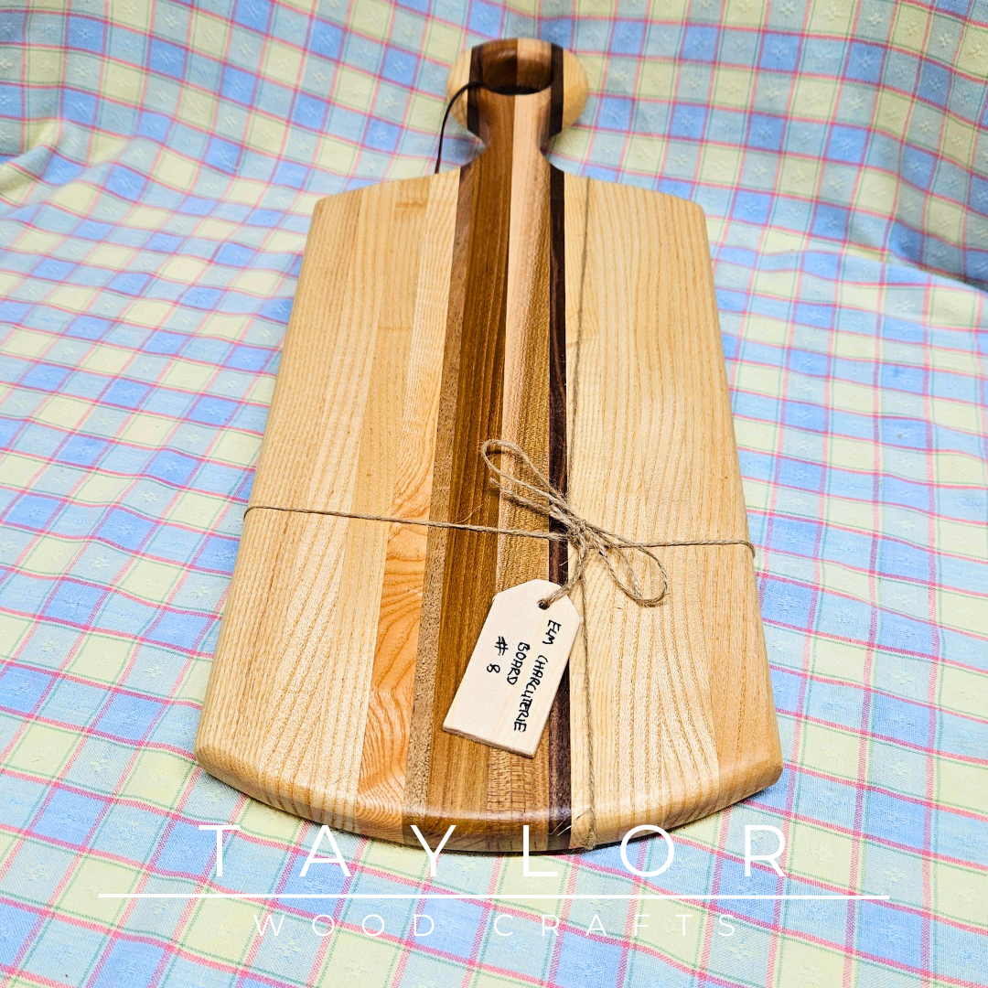 Handcrafted paddle board made with elm, ash, and walnut, featuring a leather string for hanging, combining durability and rustic style.