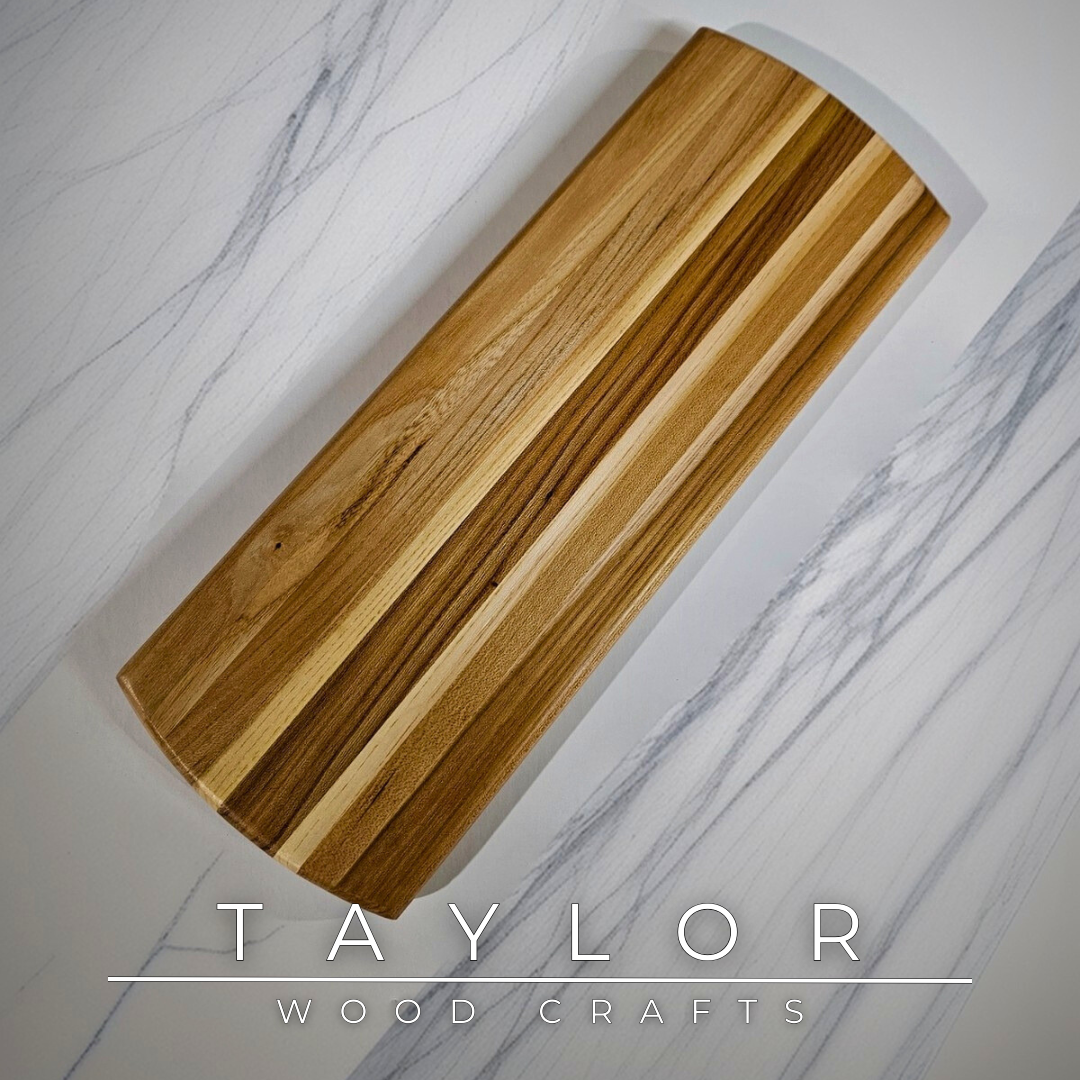Charcuterie board shaped like a paddle board, made from quality wood with rich grain, perfect for serving snacks and appetizers.