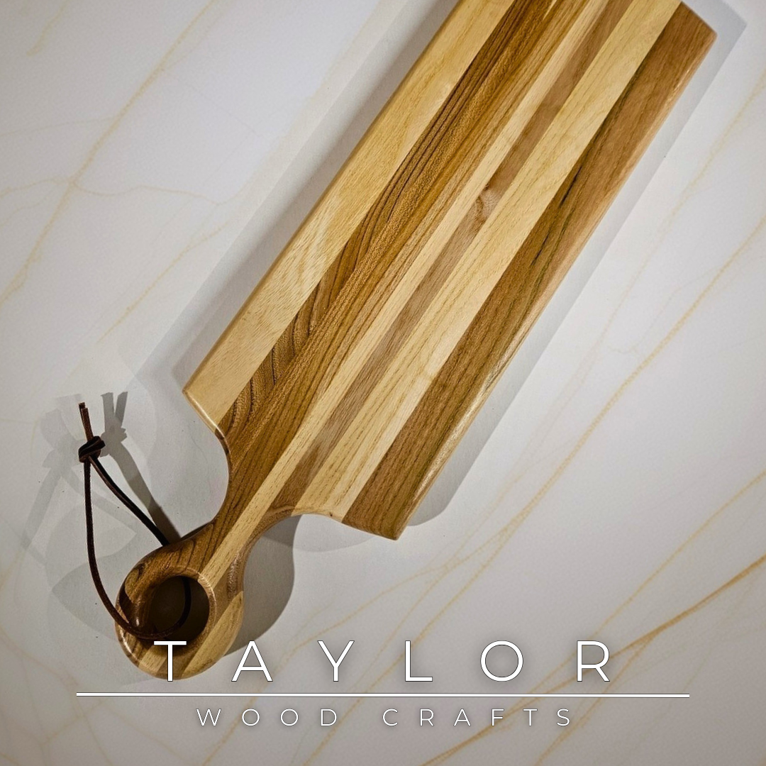 Charcuterie board shaped like a paddle board, made from quality wood with rich grain, perfect for serving snacks and appetizers.