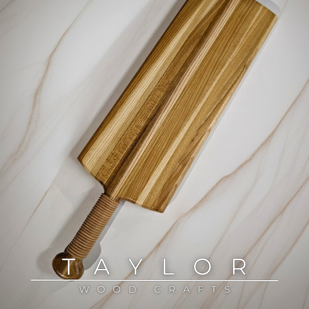 Charcuterie board shaped like a paddle board, made from quality wood with rich grain, perfect for serving snacks and appetizers.