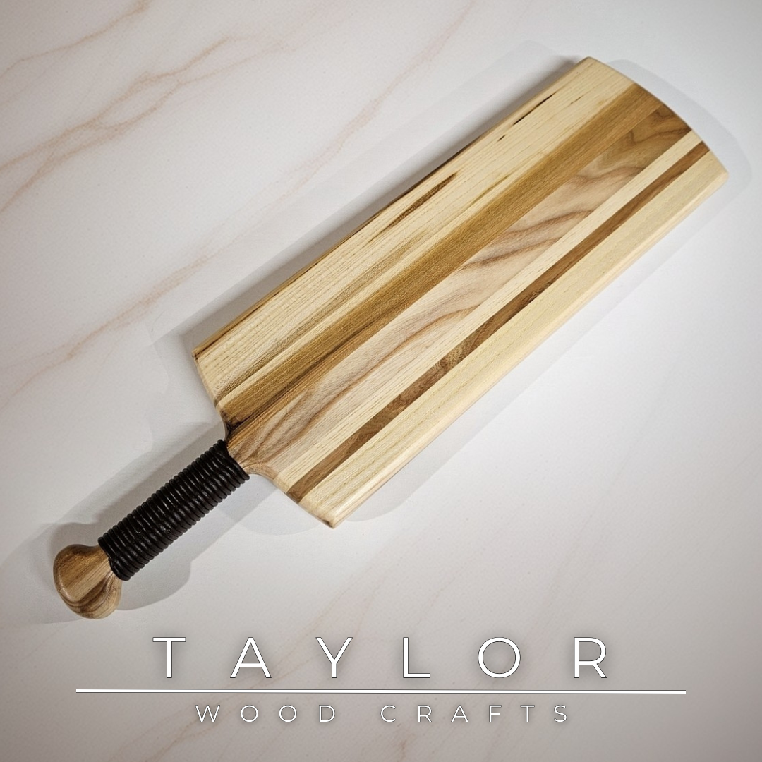 Charcuterie board shaped like a paddle board, made from quality wood with rich grain, perfect for serving snacks and appetizers.