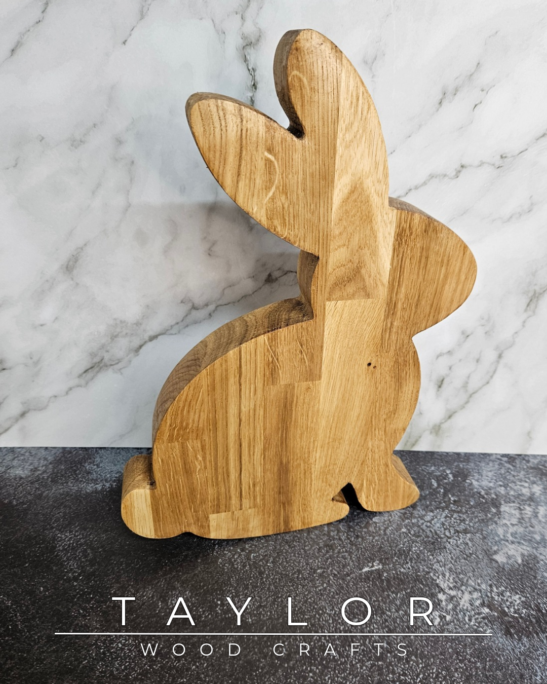 Wooden rabbit-shaped cutting board on a marble surface with 'Taylor Wood Crafts' branding.