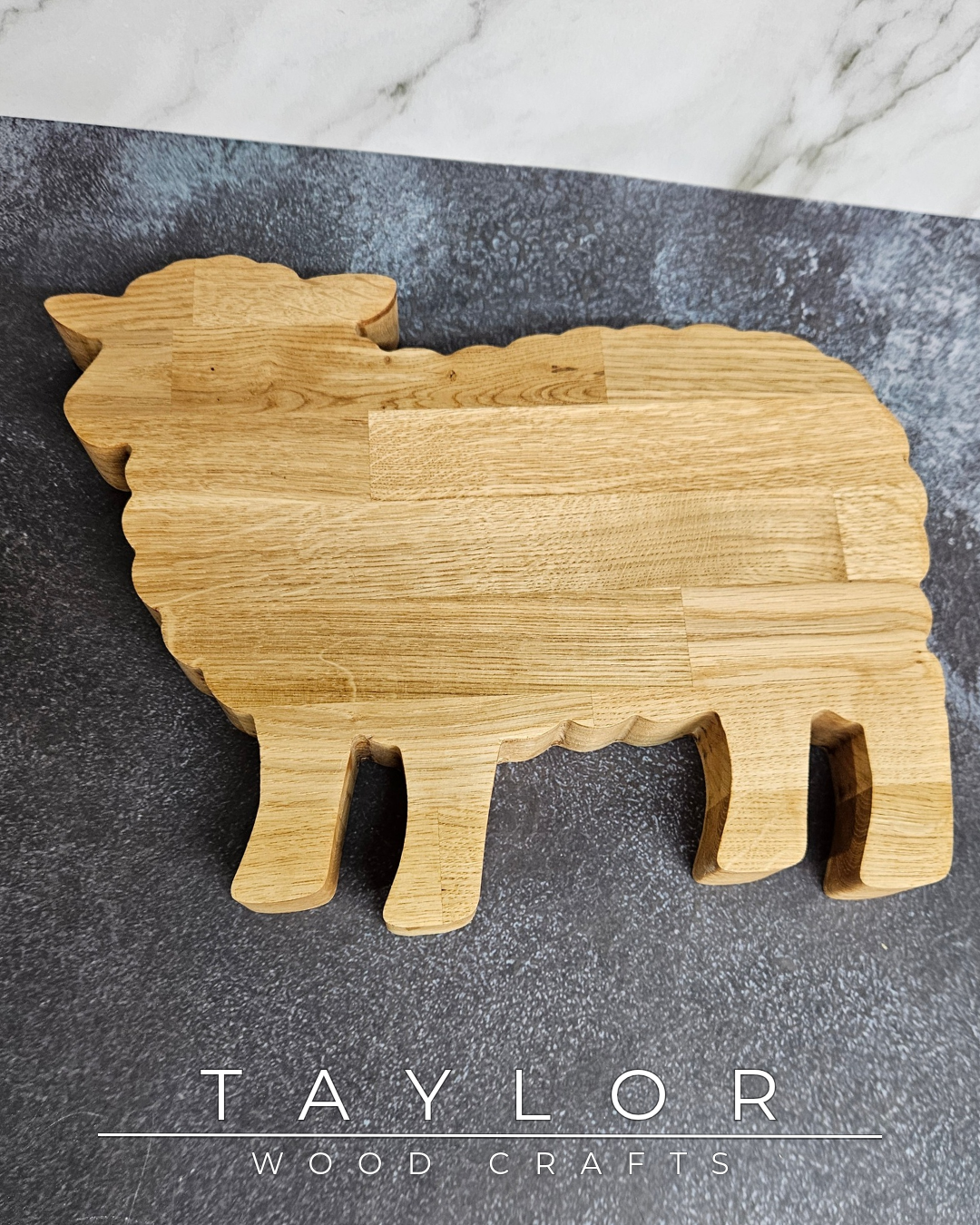 Wooden sheep-shaped cutting board on a dark surface with 'Taylor Wood Crafts' branding.