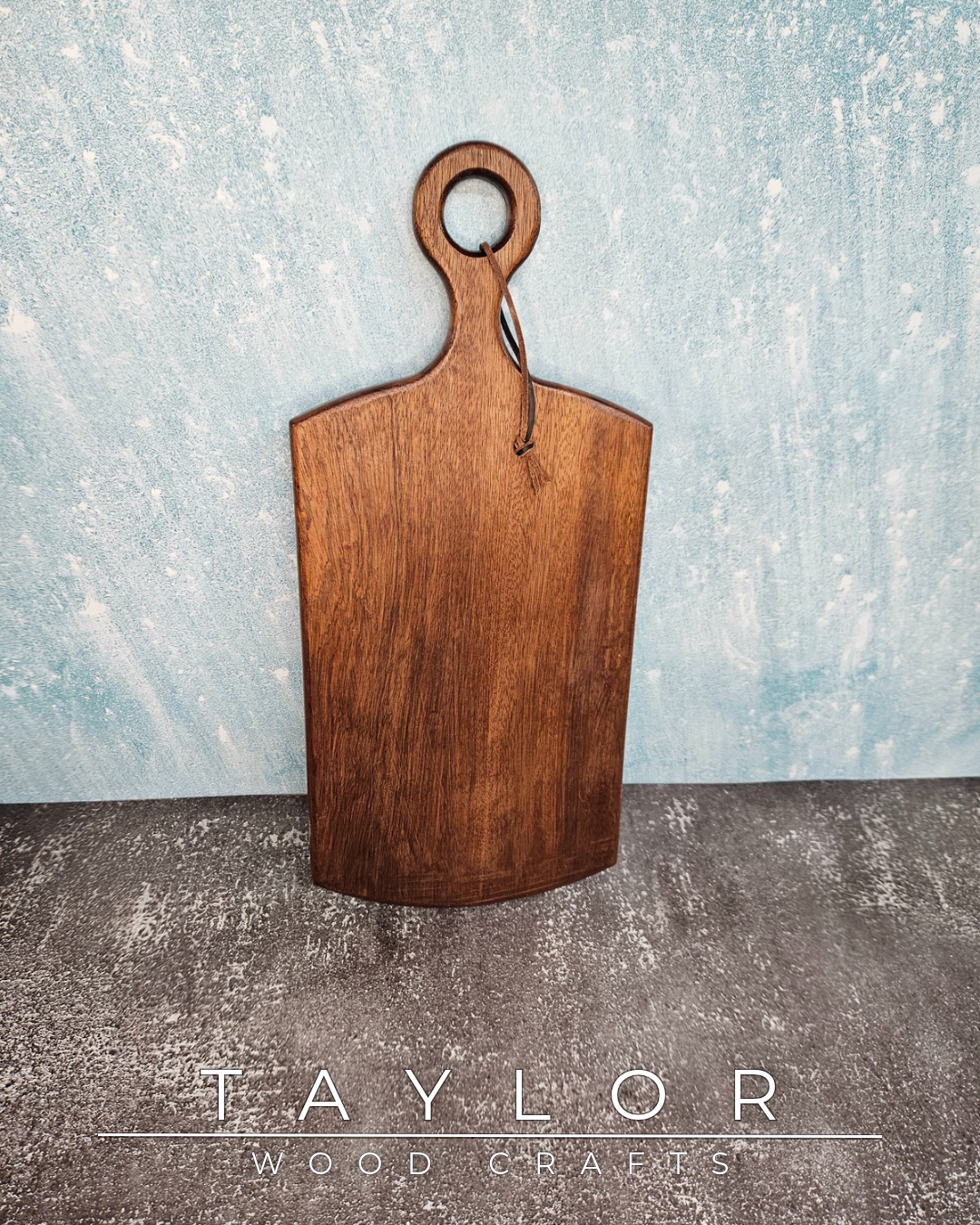 Handcrafted cherry wood paddle board with a smooth, polished surface, highlighting natural grain, perfect as a functional or decorative piece.