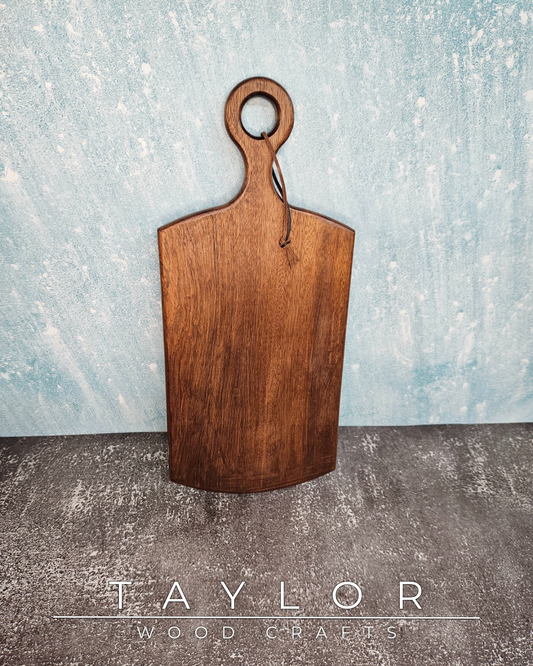 Handcrafted cherry wood paddle board with a smooth, polished surface, highlighting natural grain, perfect as a functional or decorative piece.