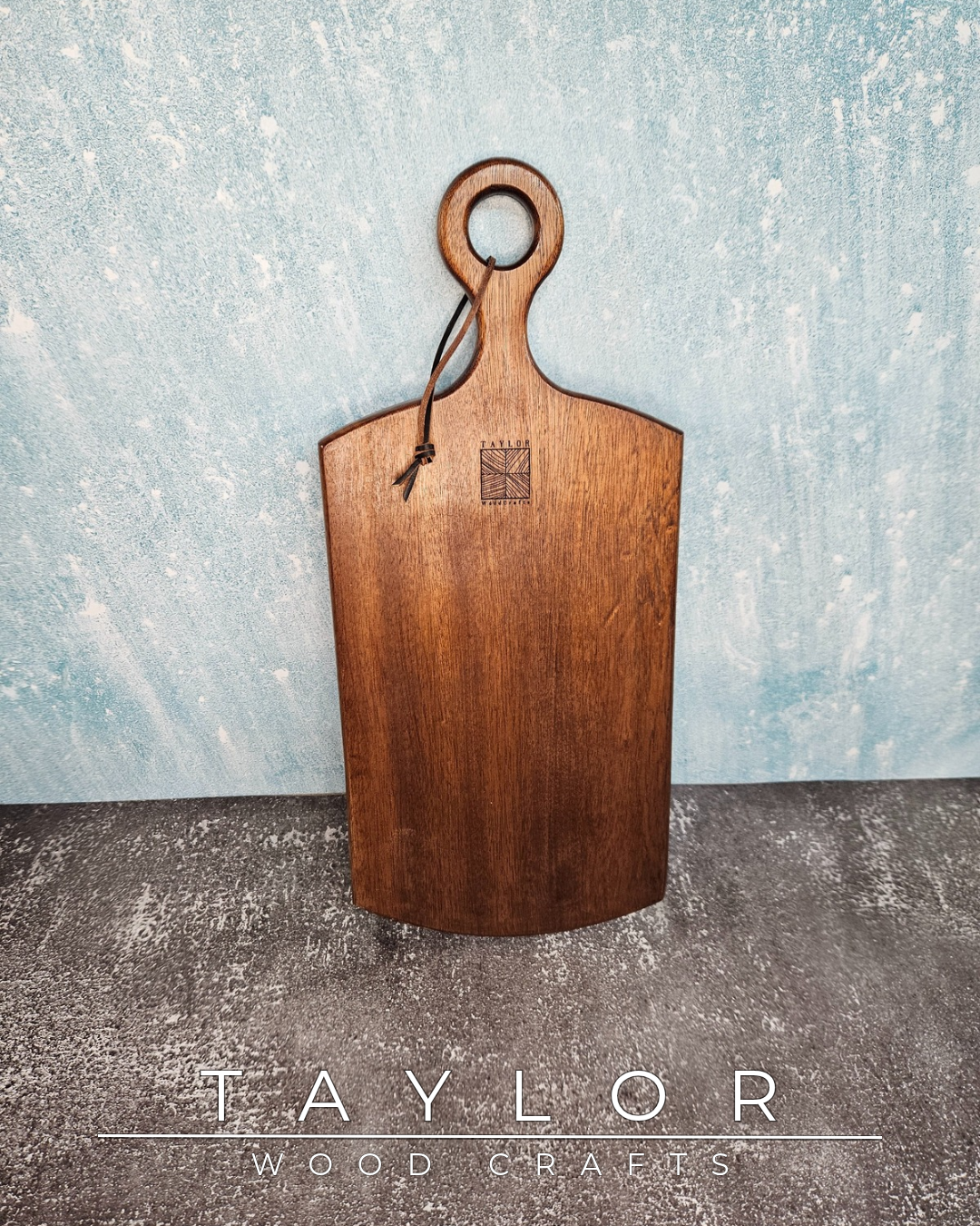 Handcrafted cherry wood paddle board with a smooth, polished surface, highlighting natural grain, perfect as a functional or decorative piece.
