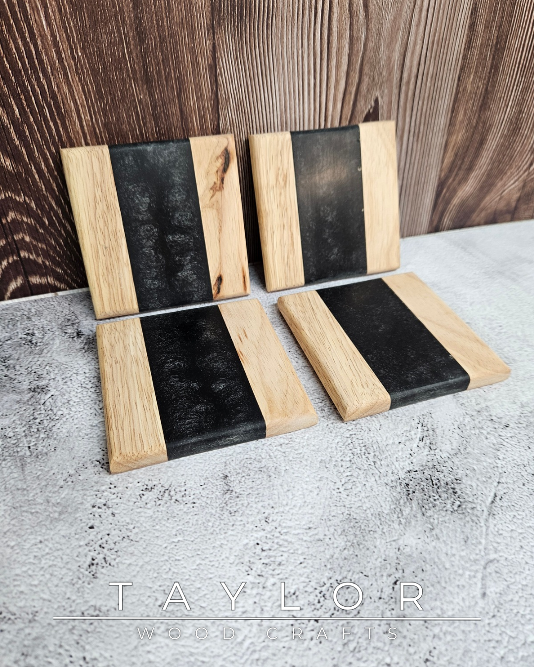 Four black and wood coasters on a textured surface with 'TAYLOR' branding.