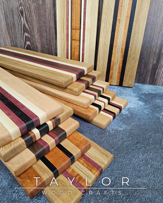 Wooden cutting boards with striped patterns on a textured surface, branded 'Taylor Wood Crafts'.