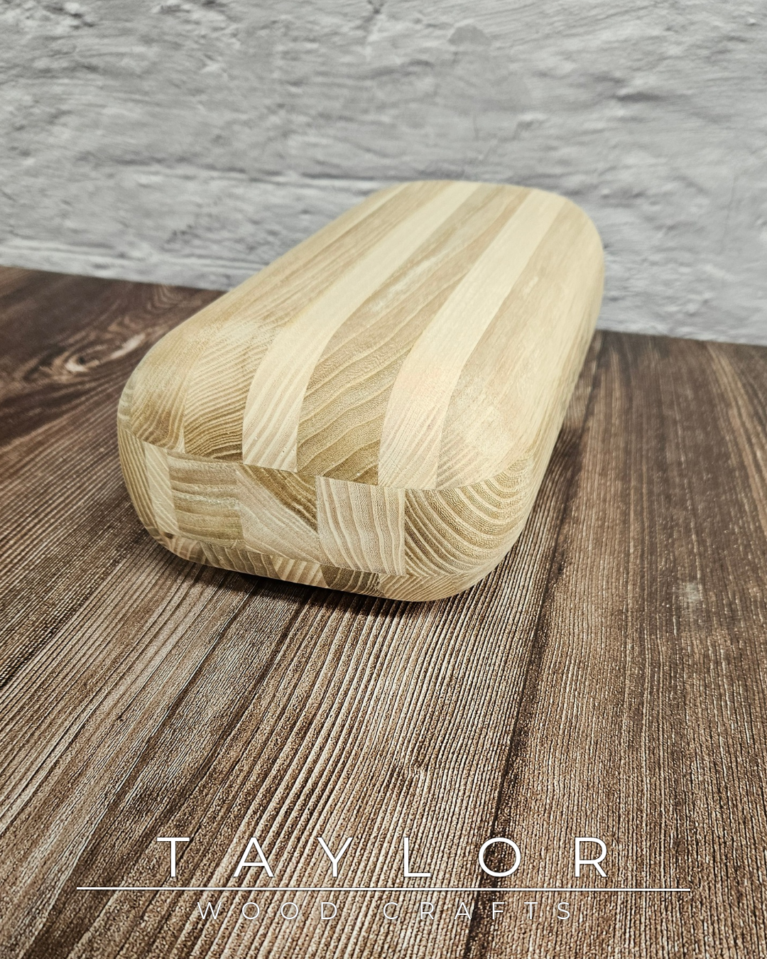 Wooden bread board with 'Taylor' branding on a wooden surface