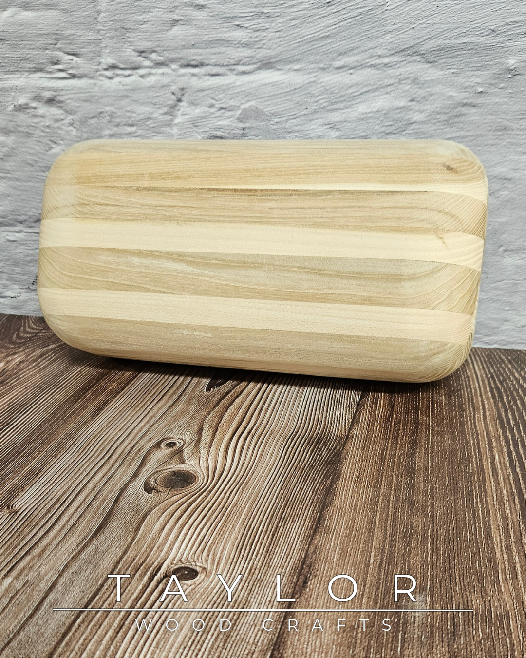 Wooden cutting board on a wooden surface with 'Taylor Wood Crafts' branding.