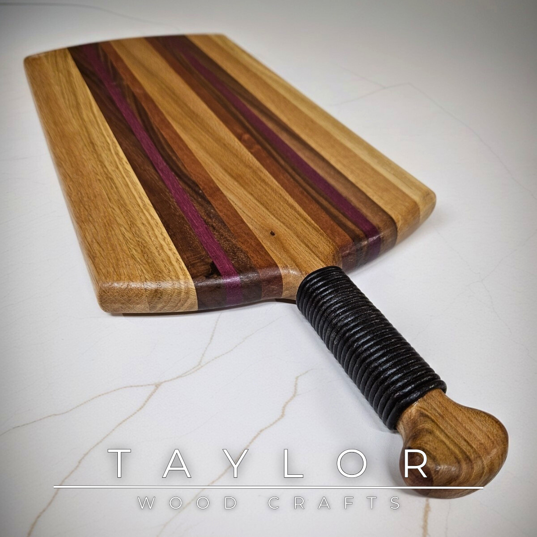 Unique charcuterie board by Taylor Wood Crafts, made from mixed hardwoods with a leather-wrapped handle.