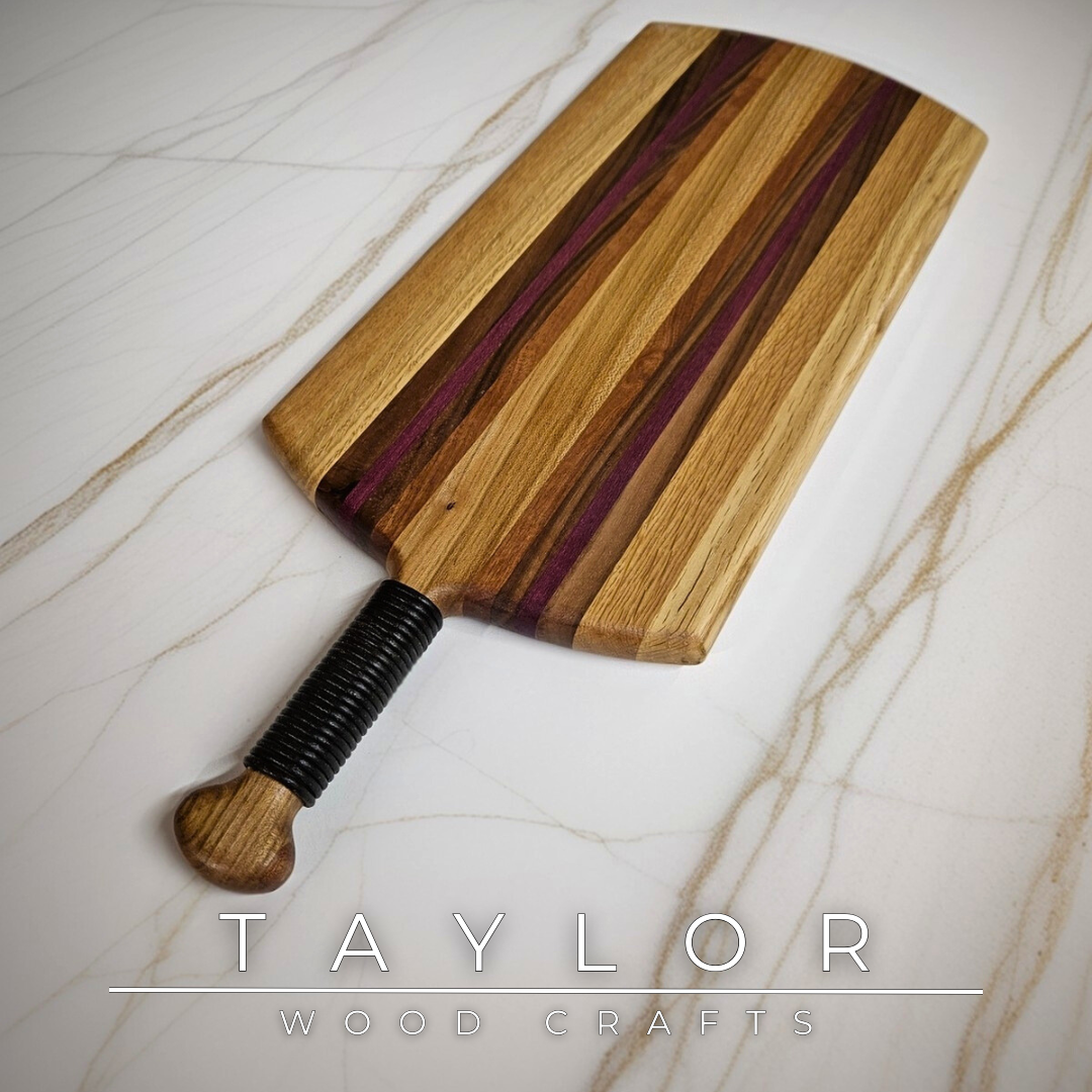 Unique charcuterie board by Taylor Wood Crafts, made from mixed hardwoods with a leather-wrapped handle.