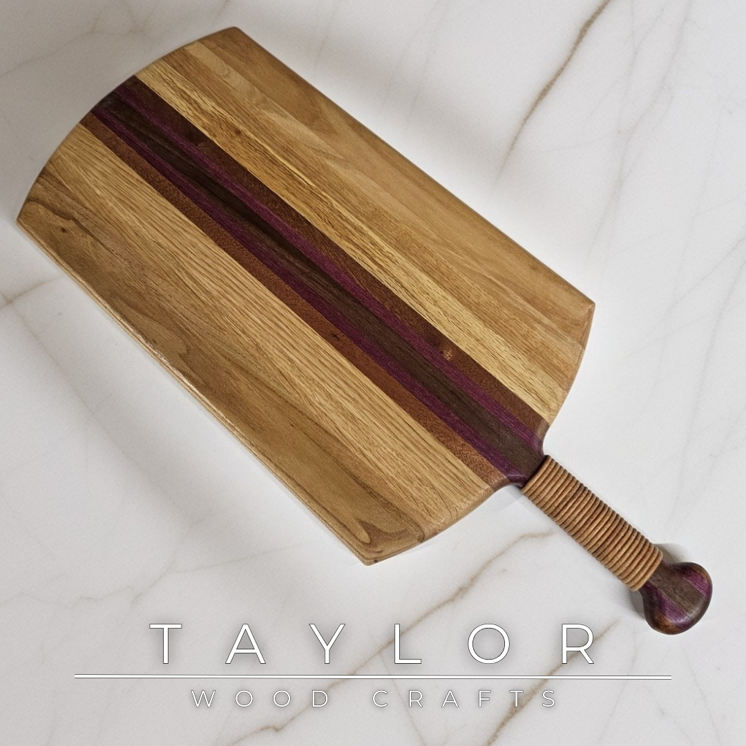 Unique charcuterie board by Taylor Wood Crafts, made from mixed hardwoods with a leather-wrapped handle.