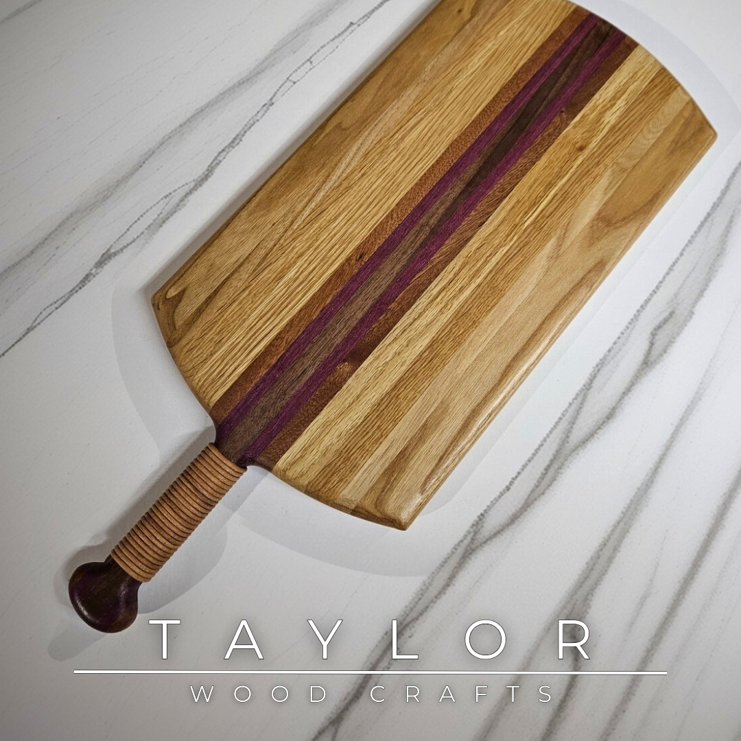 Unique charcuterie board by Taylor Wood Crafts, made from mixed hardwoods with a leather-wrapped handle.