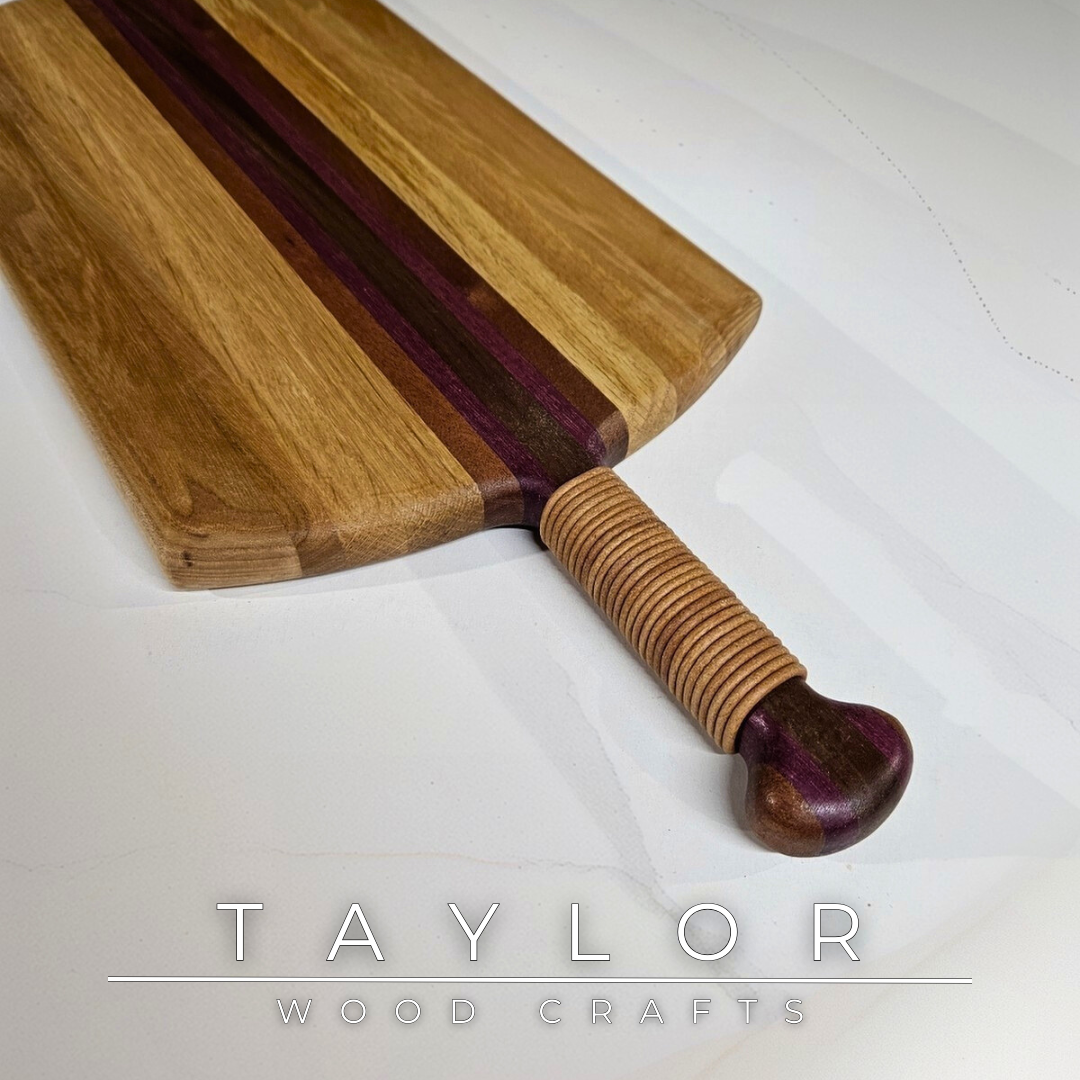 Unique charcuterie board by Taylor Wood Crafts, made from mixed hardwoods with a leather-wrapped handle.