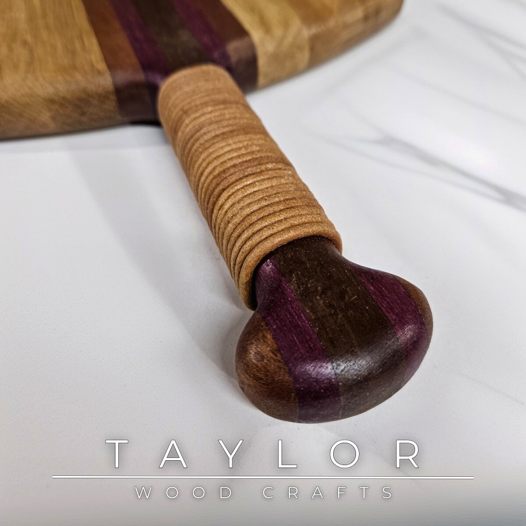 Unique charcuterie board by Taylor Wood Crafts, made from mixed hardwoods with a leather-wrapped handle.