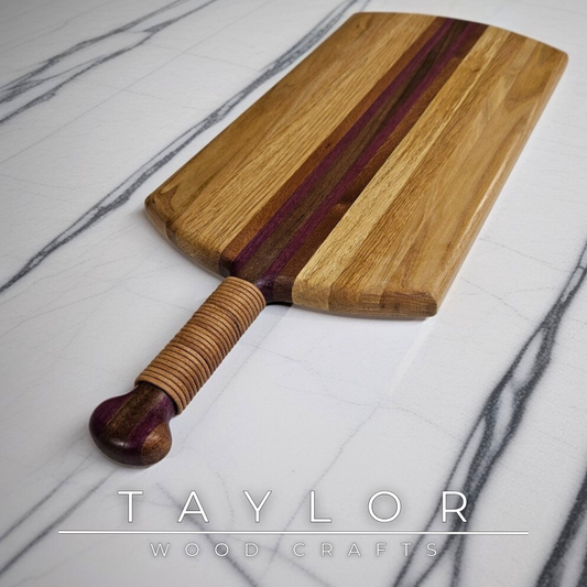 Unique charcuterie board by Taylor Wood Crafts, made from mixed hardwoods with a leather-wrapped handle.