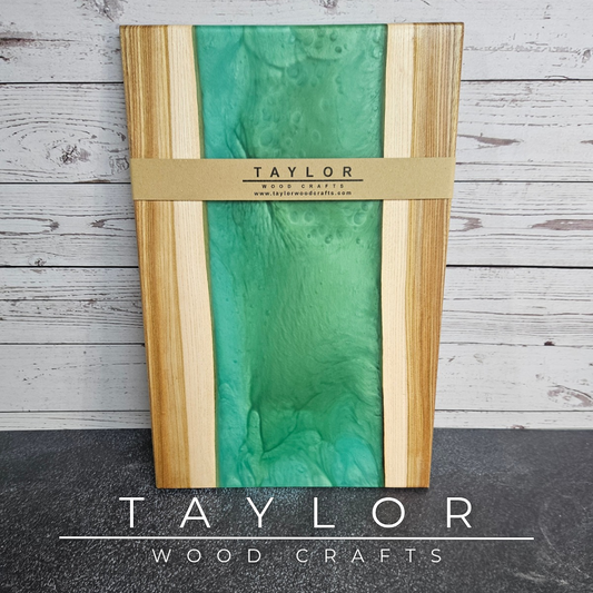 Handmade epoxy resin river charcuterie boards combining natural hardwood with striking resin designs, crafted in Northern Ireland for serving food and entertaining guests.