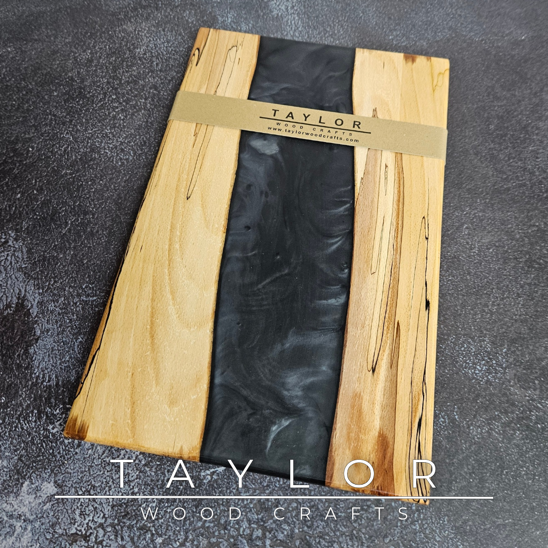 Handmade epoxy resin river charcuterie boards combining natural hardwood with striking resin designs, crafted in Northern Ireland for serving food and entertaining guests.