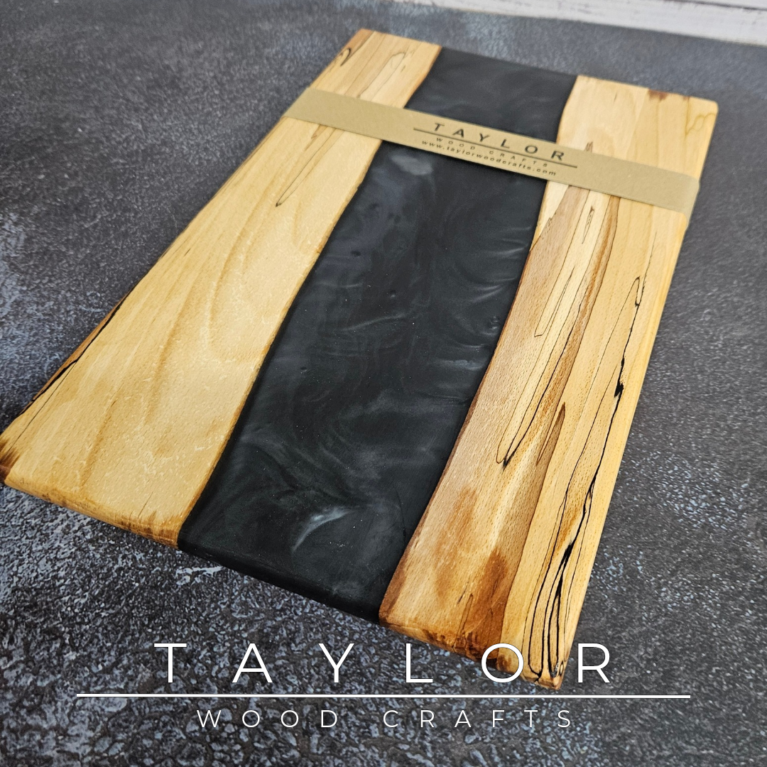 Handmade epoxy resin river charcuterie boards combining natural hardwood with striking resin designs, crafted in Northern Ireland for serving food and entertaining guests.