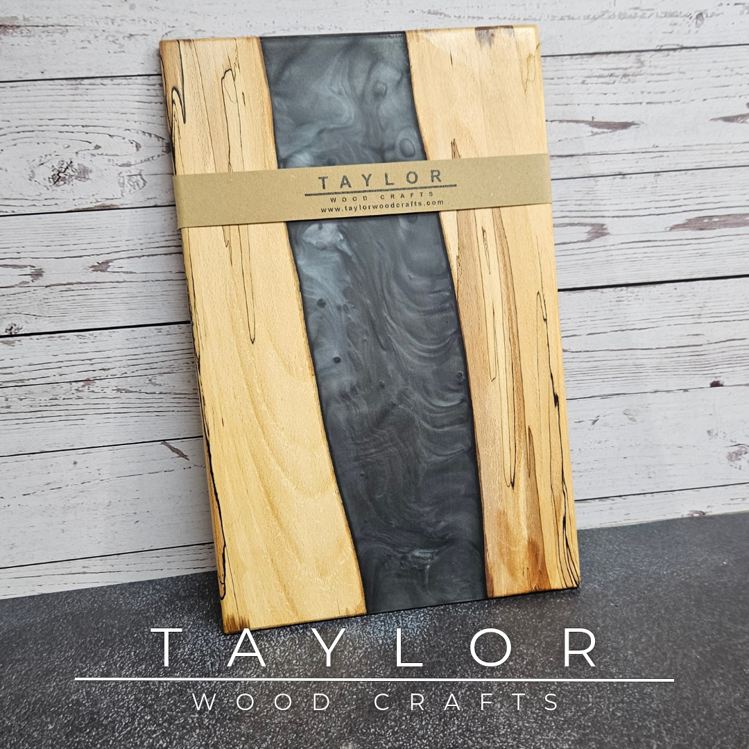 Handmade epoxy resin river charcuterie boards combining natural hardwood with striking resin designs, crafted in Northern Ireland for serving food and entertaining guests.