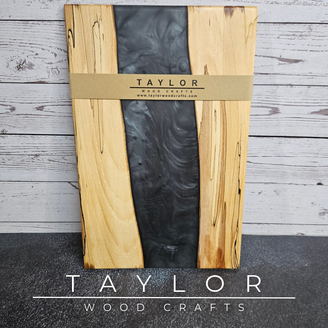 Handmade epoxy resin river charcuterie boards combining natural hardwood with striking resin designs, crafted in Northern Ireland for serving food and entertaining guests.