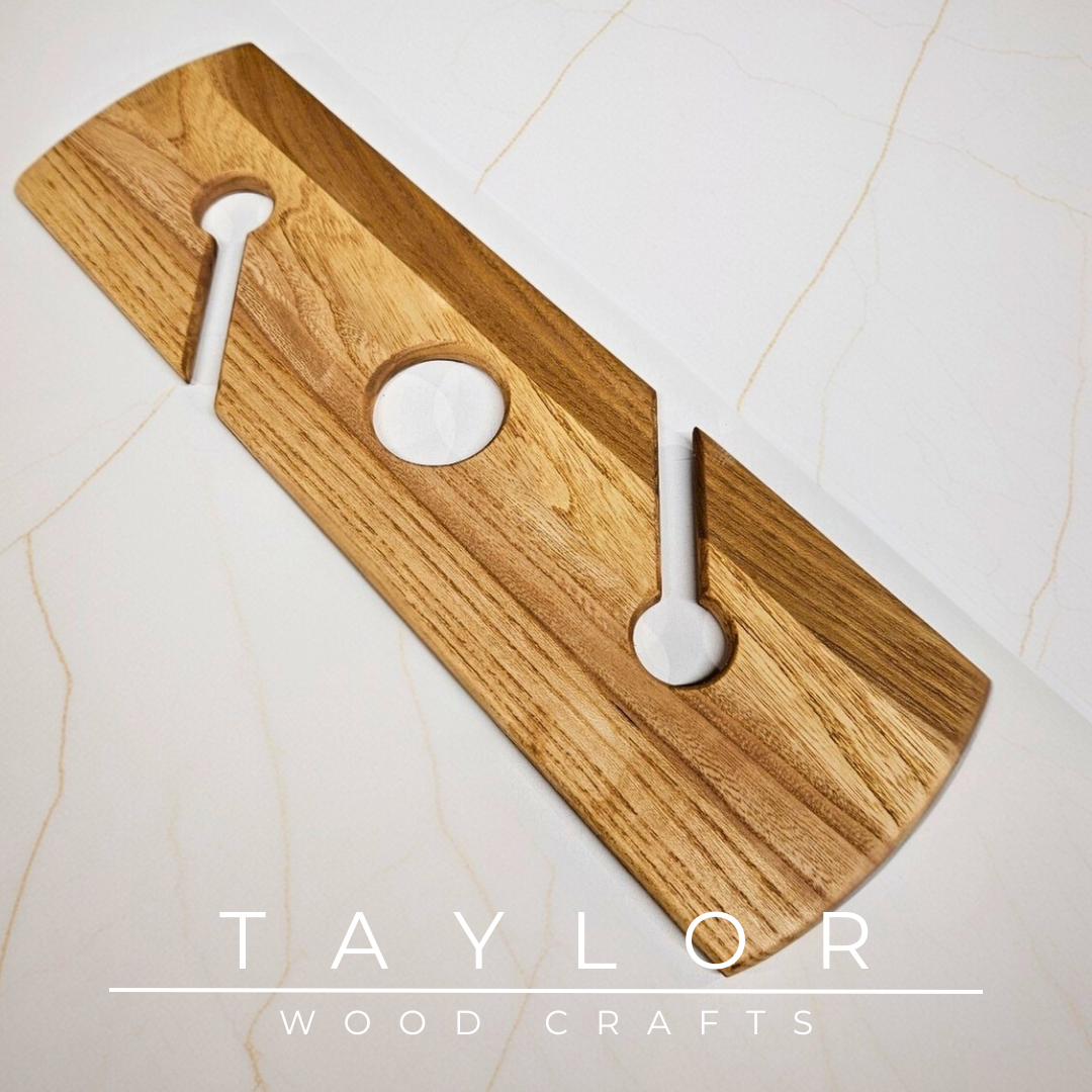 Wooden cutting board with circular holes on a marble surface, branded 'Taylor Wood Crafts'.